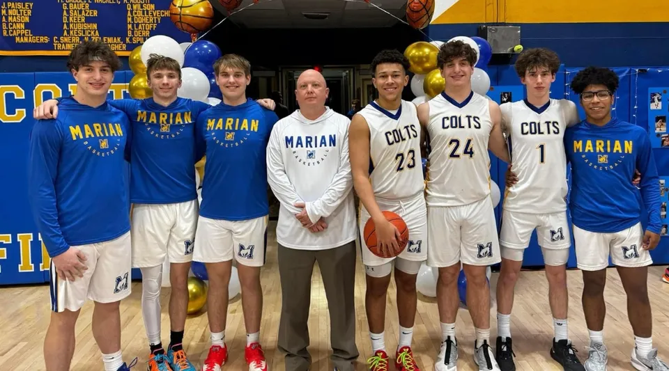 Studenti della Marian Catholic High School posano insieme nella palestra con un campo da basket sullo sfondo.