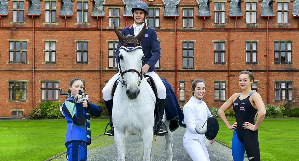 Quattro studenti dell'Ellesmere College in tenuta sportiva posano davanti all'edificio in mattoni rossi della scuola.