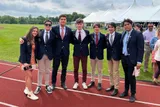 Aitana y sus compañeros de internado, con blazer y corbata, posan en la pista de atletismo