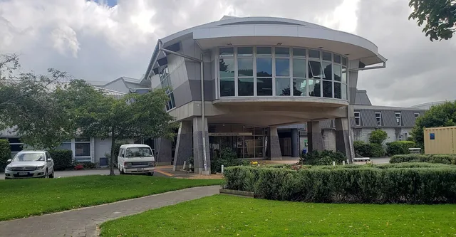 Il moderno edificio della Hutt Valley High School ha una facciata in vetro curva e un tetto a cupola, immerso in un'area verde ben tenuta.