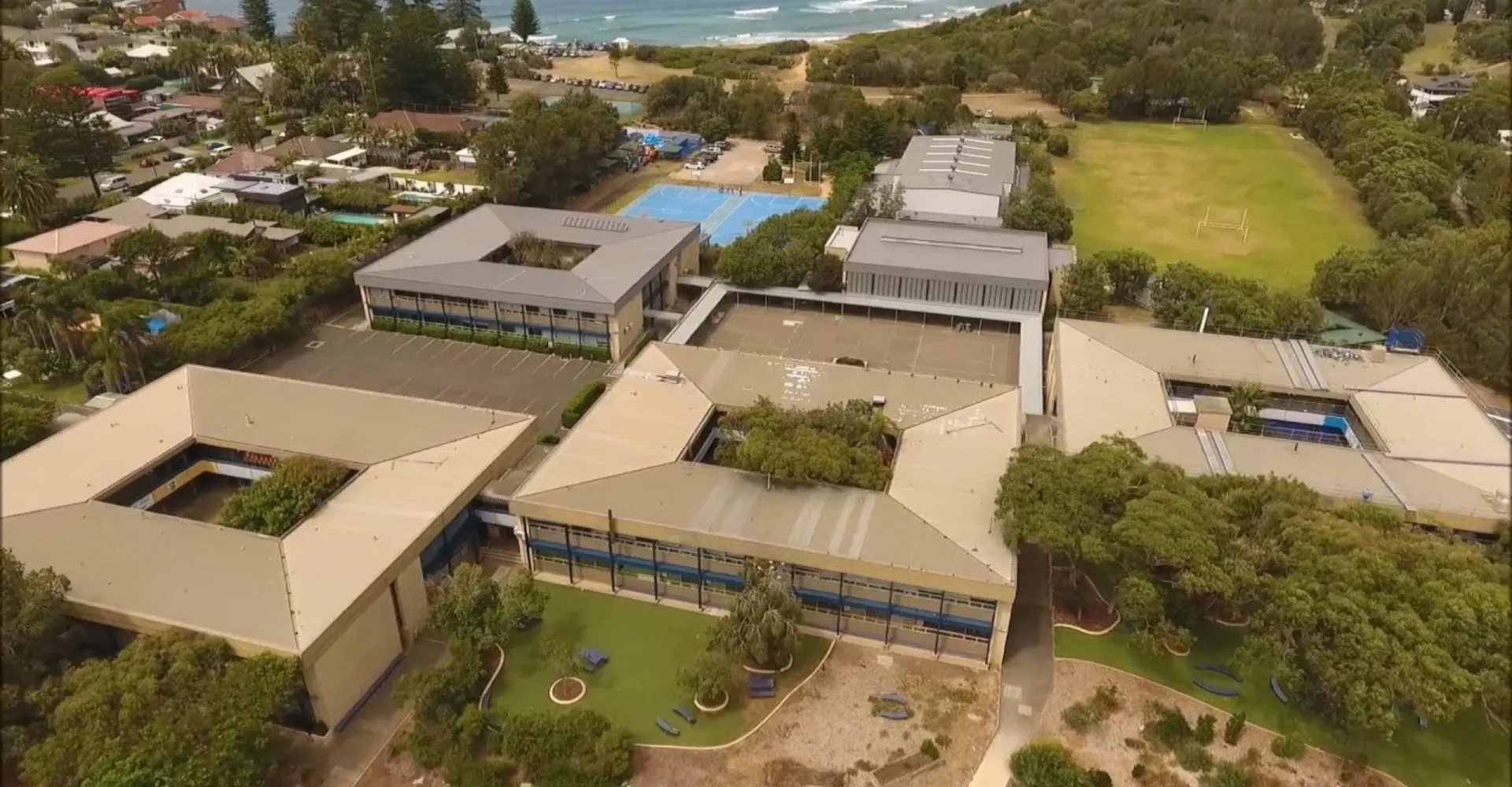 Il moderno complesso edilizio della Barrenjoey High School è circondato dal verde e presenta un'area esterna con piscina.