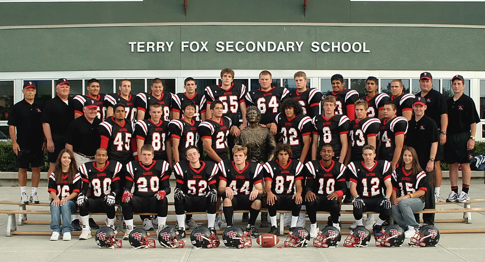 Un gruppo di studenti della Terry Fox Secondary School posa davanti a uno striscione con il nome della scuola sullo sfondo.