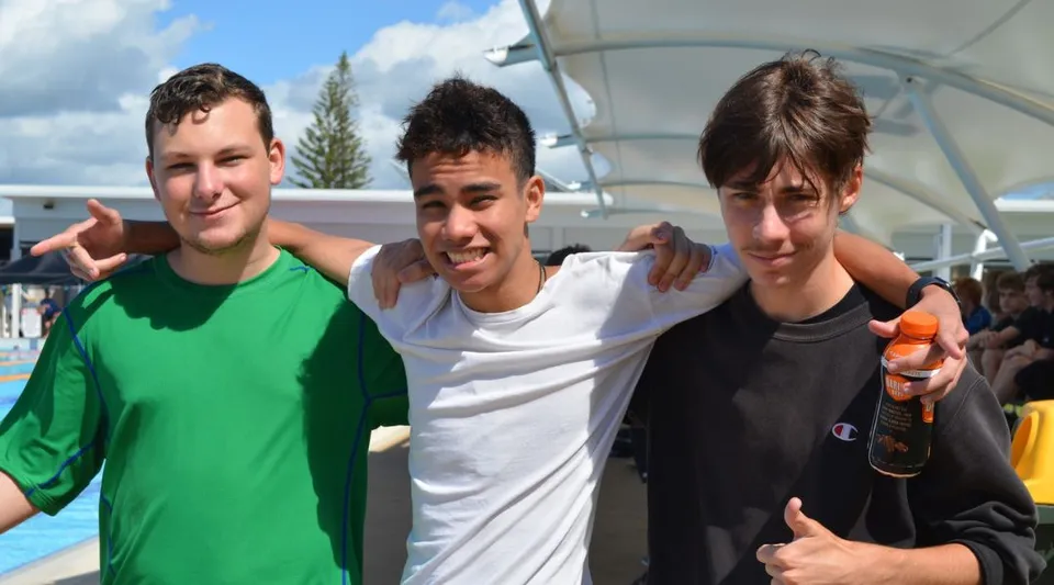 Tre studenti stanno insieme all'aperto nel campus della Ballina Coast High School.