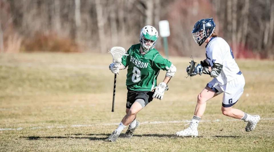 Due giocatrici in divisa da lacrosse si sfidano sul campo della Hebron Academy.