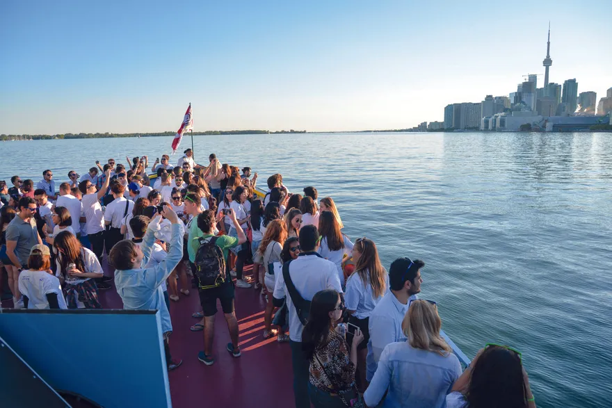 Schüler der ILAC International High School auf einem Boot vor der Skyline von Toronto