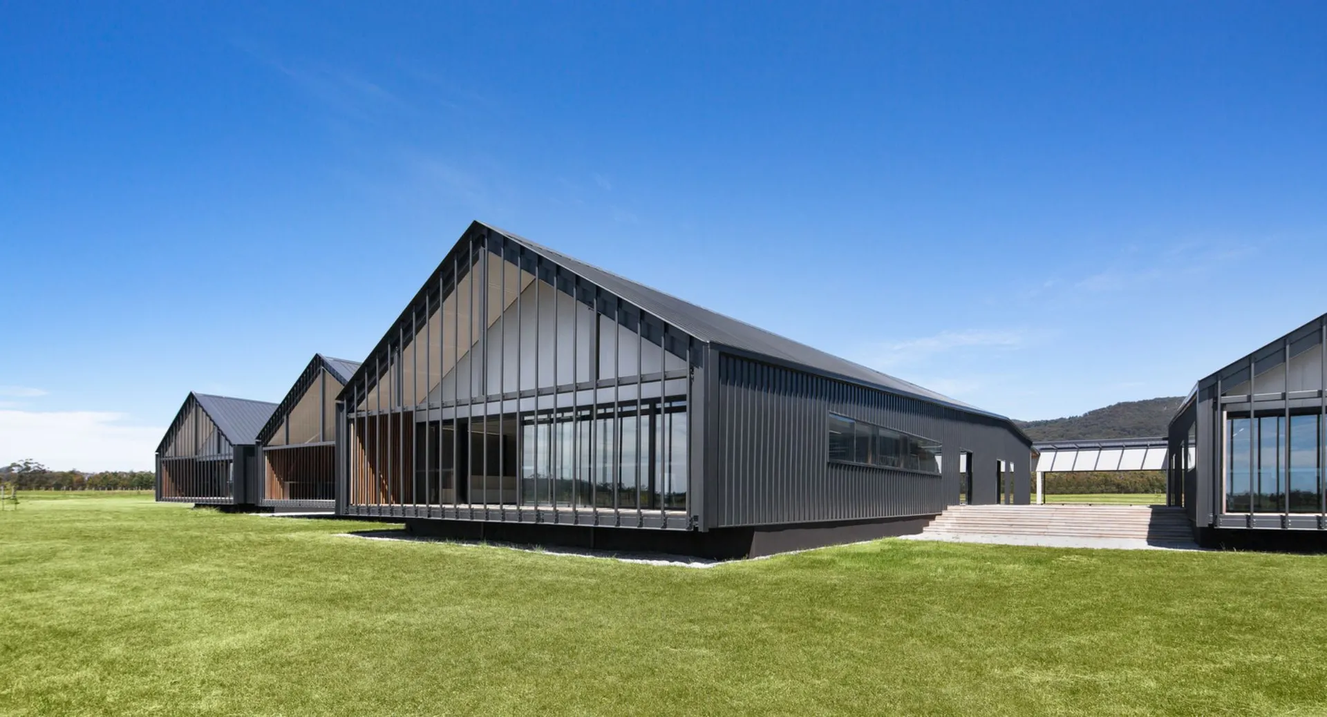 L'edificio moderno del Braemar College sorge su un prato sotto un cielo azzurro e limpido.