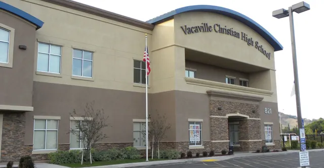 Das mehrstöckige Gebäude der Vacaville Christian School ist mit einem Schild an der Fassade und sichtbarer Landschaftsgestaltung im Vordergrund zu sehen.