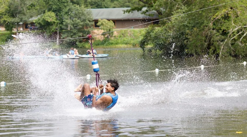 Uno studente o una studentessa della Winston Salem Christian School fa wakeboard dietro a una barca in acqua.