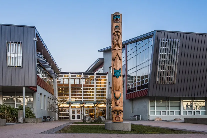 Un totem in legno si trova davanti al moderno edificio della Sutherland Secondary School.