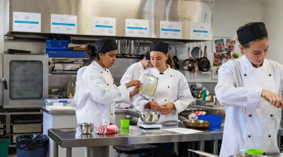 Studenti della Hillmorton High School lavorano insieme nella cucina della scuola per preparare del cibo.