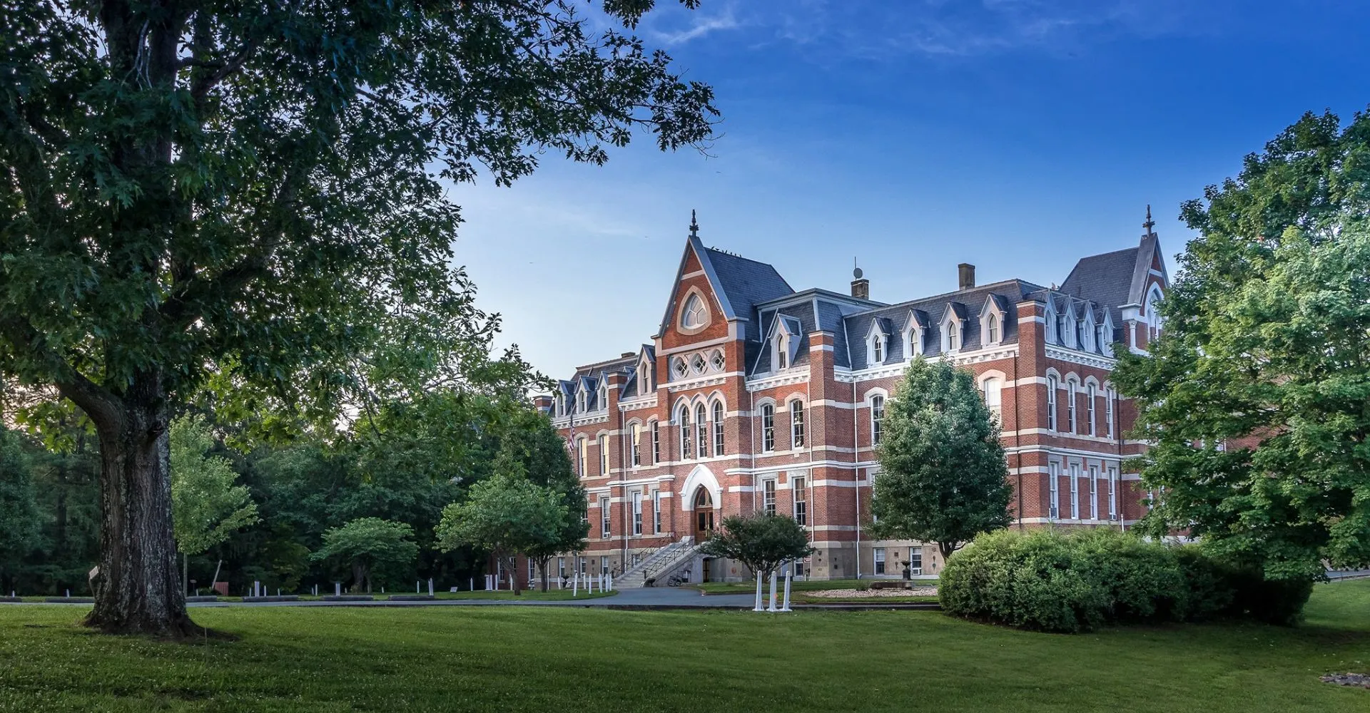 L'edificio della Miller School of Albemarle si trova immerso in un paesaggio verde con alberi e un prato ben curato.
