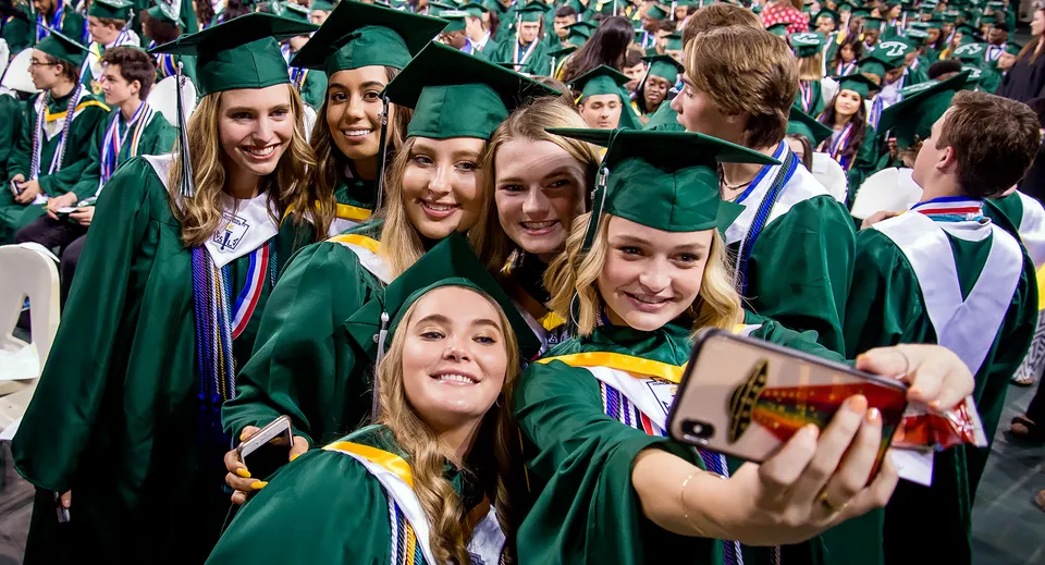 Un gruppo di diplomati della Balmoral State High School in toga verde si scatta un selfie insieme.