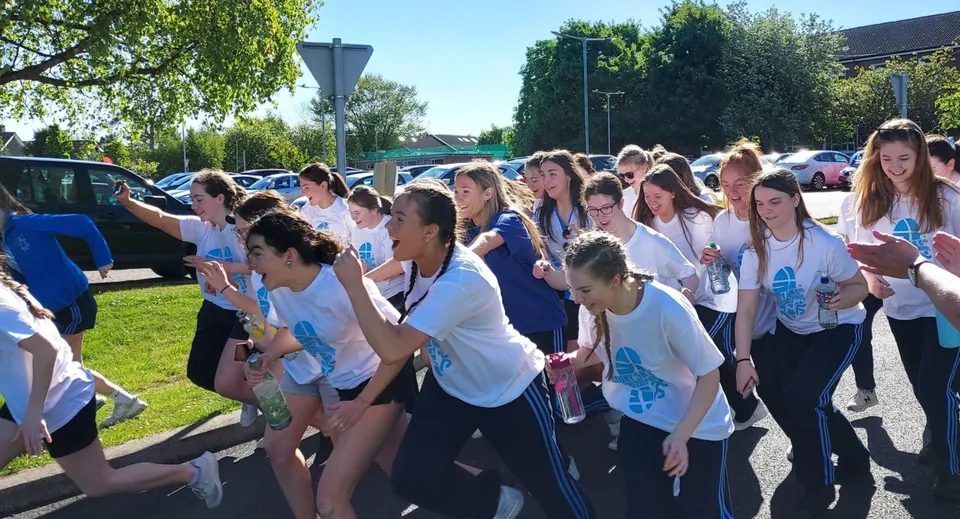 Un gruppo di giovani si trova insieme all'aperto nel campus della St. Joseph of Cluny.