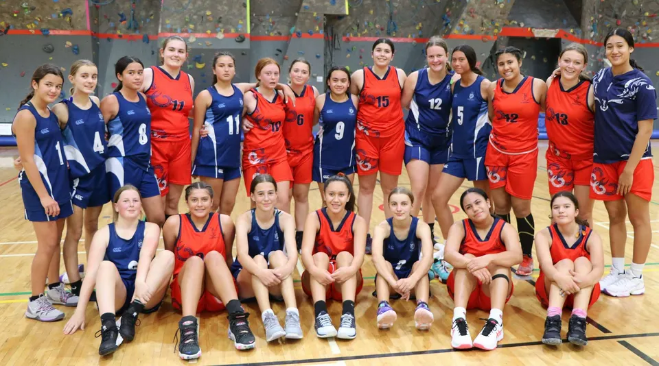 Un gruppo di giovani giocatrici di basket della Napier Girls' High School posa insieme sul campo da basket.