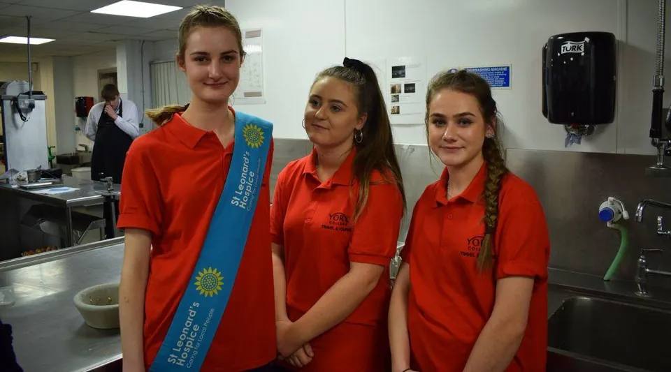 Tre studentesse in divisa rossa si trovano nella cucina del campus del York College.