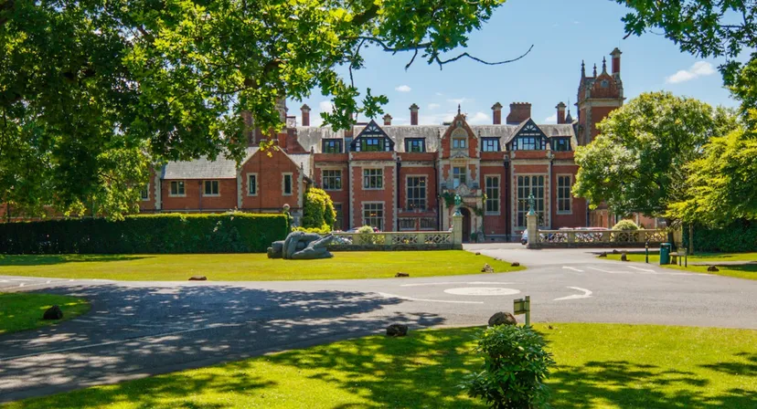 L'edificio storico della Frensham Heights School è circondato da un giardino ben curato con un sentiero e siepi.