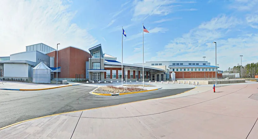 Il moderno edificio scolastico a più piani con facciata in vetro e una bandiera americana fa parte del Virginia Beach City Public School District.
