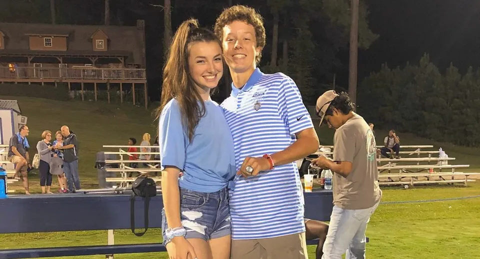 Una giovane coppia si abbraccia e sorride sul campo sportivo della Dominion Christian School.