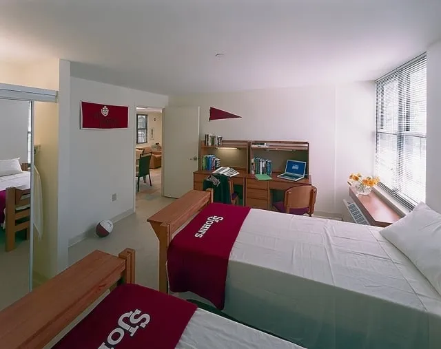Habitación doble de la residencia con dos camas, escritorio y estanterías