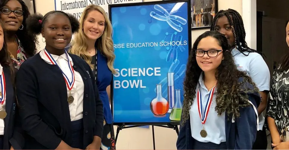Studenti della International School of Broward in piedi con medaglie davanti allo striscione di una competizione Science Bowl.