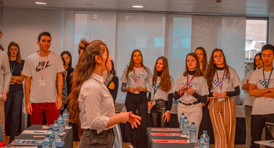 Un gruppo di studenti del King's College si riunisce in una sala per eventi con un'oratrice in primo piano.