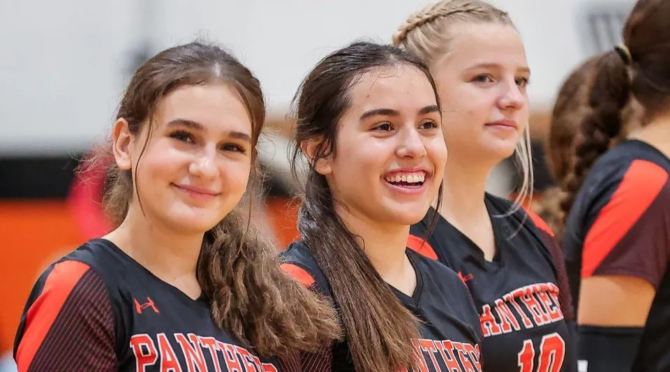 Un gruppo di studentesse della TMI Episcopal indossa divise sportive e posa insieme in un contesto sportivo.