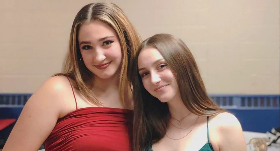 Due studentesse della St. Paul Catholic High School posano sorridenti in un ambiente interno con uno sfondo semplice.