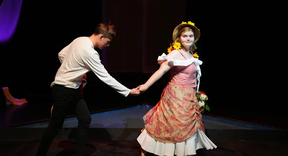 Un uomo e una donna in abiti formali ballano durante una rappresentazione sul palco della Brighton Secondary School.