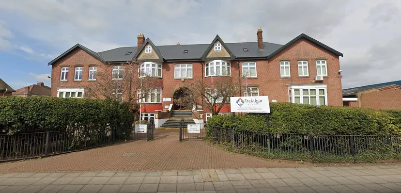 L'edificio in mattoni a più piani con finestre ad arco e tetto in tegole si trova nel campus della Trafalgar School.