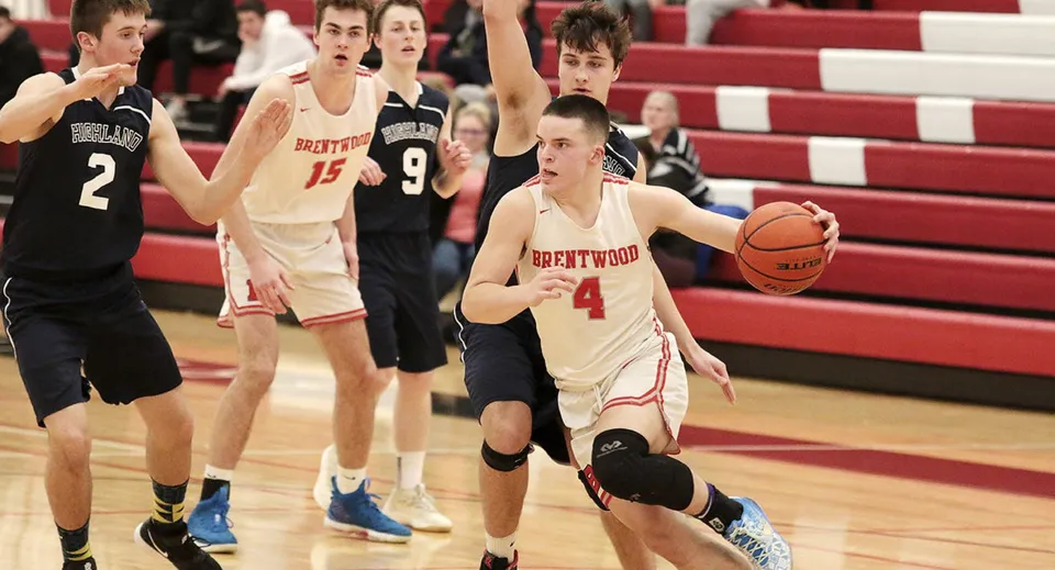 Studenti della Brentwood College School giocano a basket nel cortile della scuola davanti agli spettatori.