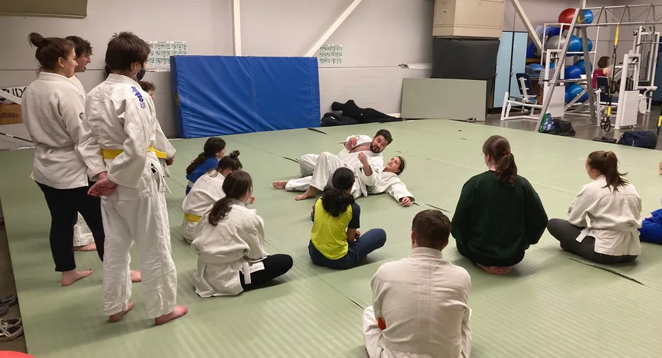 Un gruppo di studenti della Parkland Secondary School si esercita insieme nelle arti marziali su un tappetino.