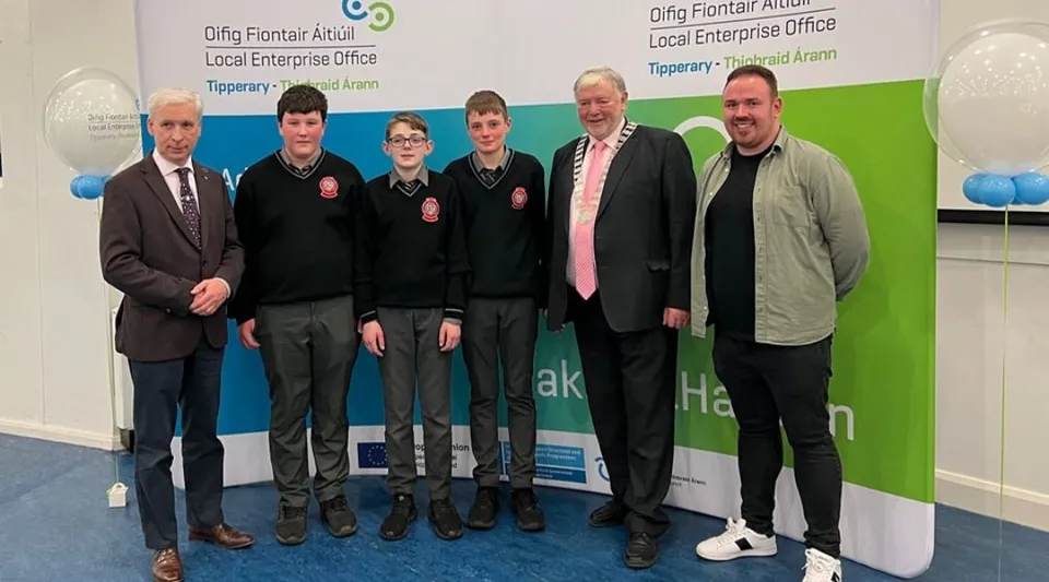 Studenti della Edmund Rice Secondary School sono in posa davanti a uno sfondo con la scritta Clonmel Enterprise Office.