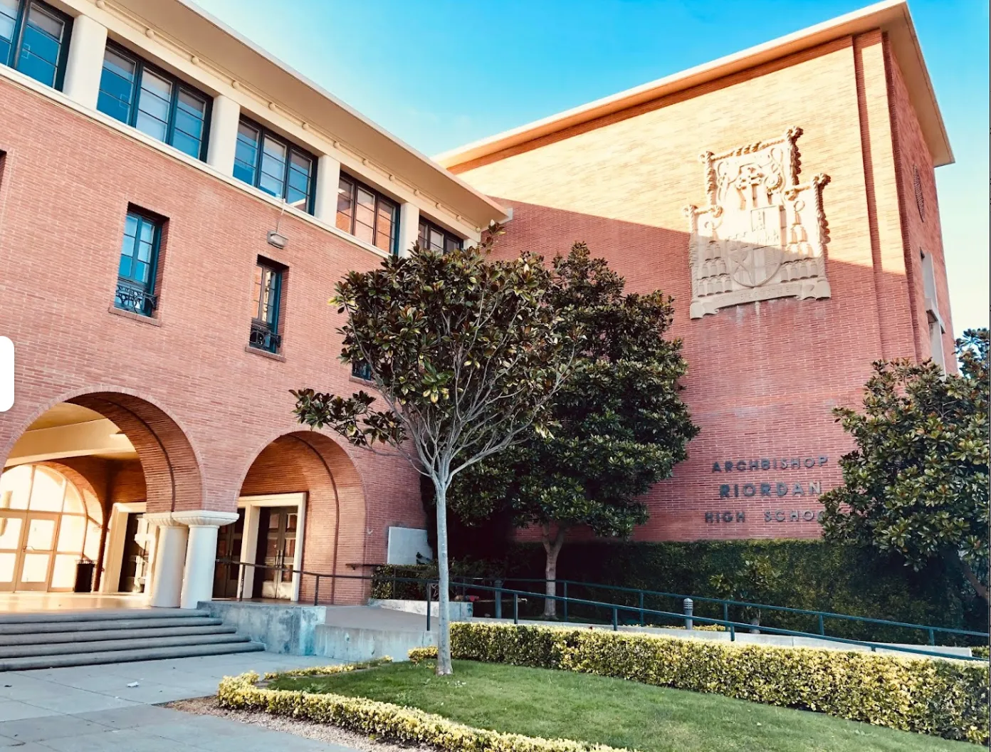 El edificio de color rosa con entradas arqueadas se encuentra en el recinto de la Archbishop Riordan High School.