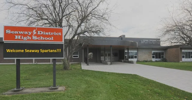 Vista esterna della Seaway District High School con un grande cartello di benvenuto per i Seaway Spartans in primo piano.