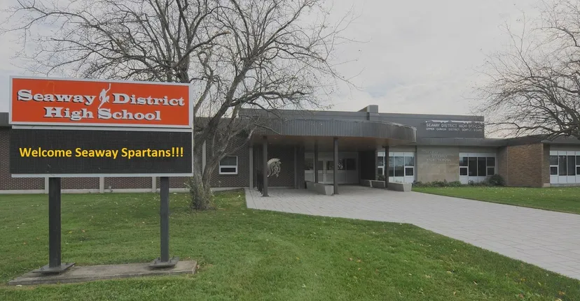 Vista esterna della Seaway District High School con un grande cartello di benvenuto per i Seaway Spartans in primo piano.
