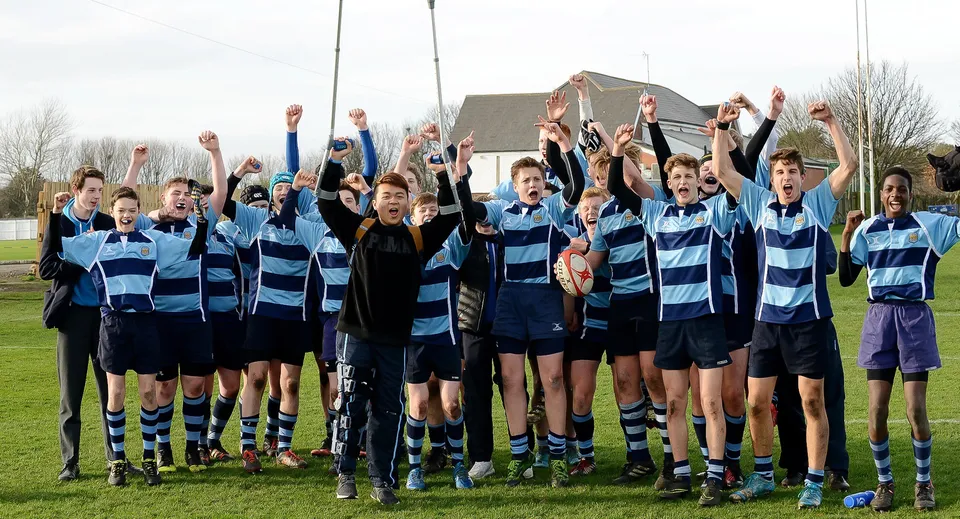 Un gruppo di studenti della Pocklington School festeggia insieme sul campo da rugby.