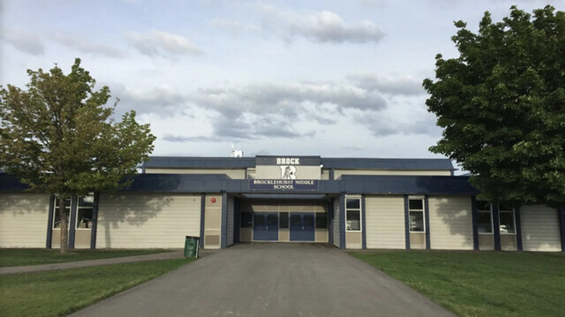 L'ingresso principale dell'edificio della Brocklehurst Secondary School con alberi e un viale d'accesso.
