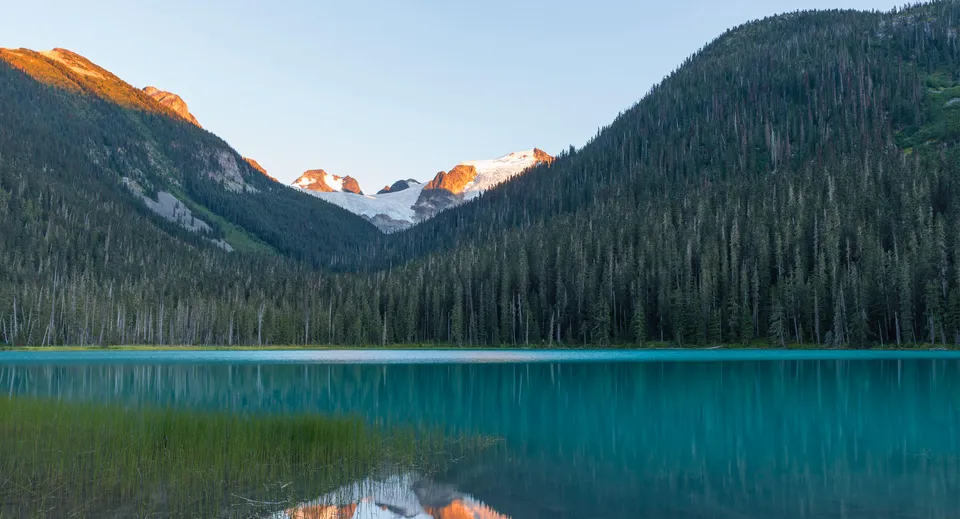 Un tranquillo lago alpino con montagne innevate e paesaggio boschivo vicino alla Ladysmith Secondary School.