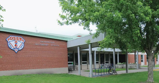 L'edificio in mattoni della Gananoque Secondary School è circondato da alberi verdi e da un prato.