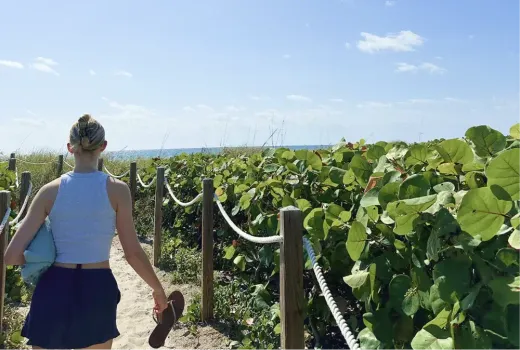 Una ragazza cammina su un sentiero sabbioso verso la spiaggia negli Stati Uniti.