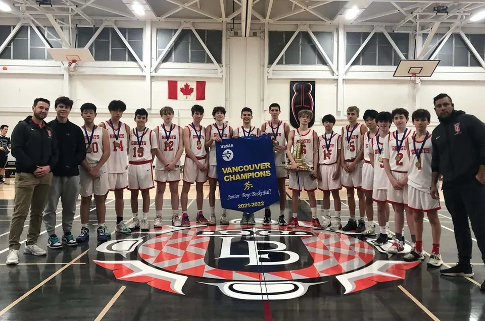 Un gruppo di studenti della Lord Byng Secondary School si trova nella palestra con uno striscione per la vittoria del campionato di basket.