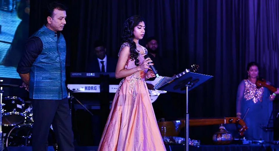 Una studentessa canta con un microfono sul palco del Sir John A. Macdonald Collegiate Institute durante un'esibizione.