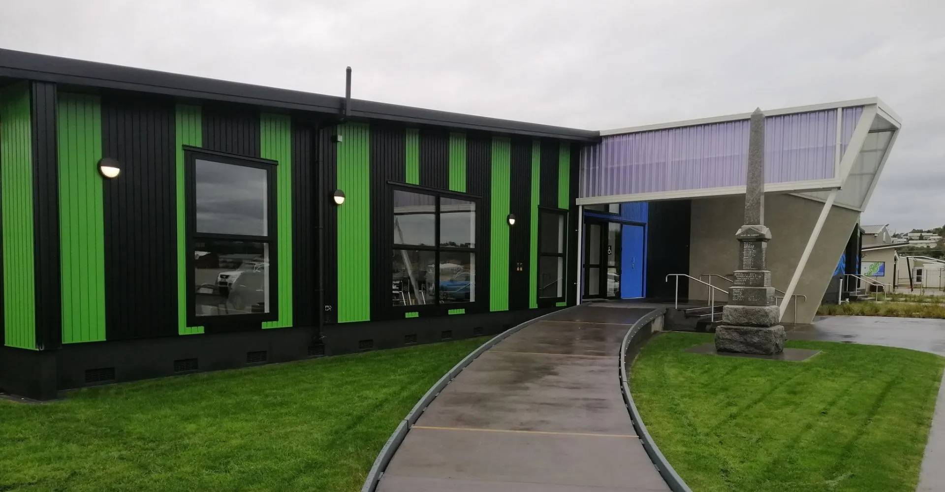 L'edificio moderno verde e nero della Westland High School con un sentiero pavimentato e un'area verde.