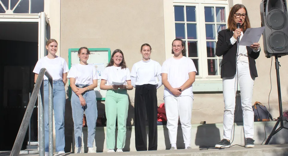 Un gruppo di studenti si trova davanti all'edificio della Institution Mongazon e tiene in mano dei fogli.