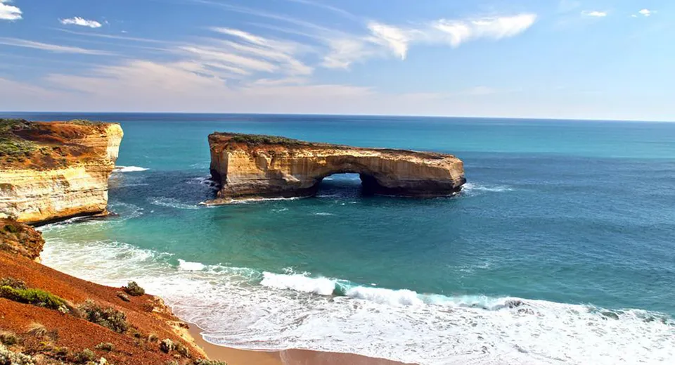 Un suggestivo paesaggio costiero con formazioni rocciose e acqua turchese sotto un cielo blu.