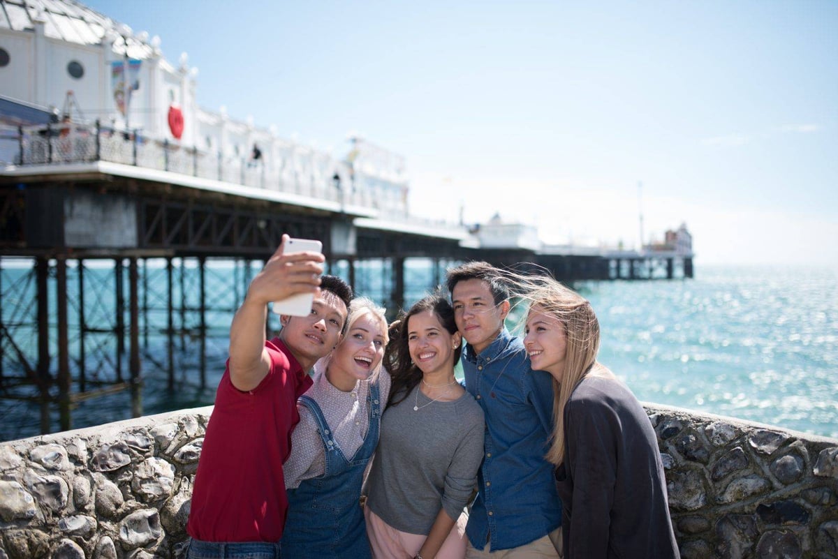 Schülergruppe macht ein Selfie vor dem Palace Pier in Brighton
