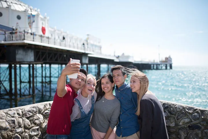 Schülergruppe macht ein Selfie vor dem Palace Pier in Brighton