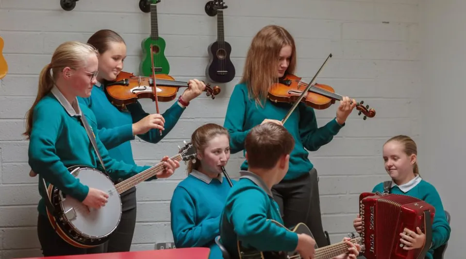 Un gruppo di studenti suona diversi strumenti musicali nell'aula di musica del Portumna Community College.