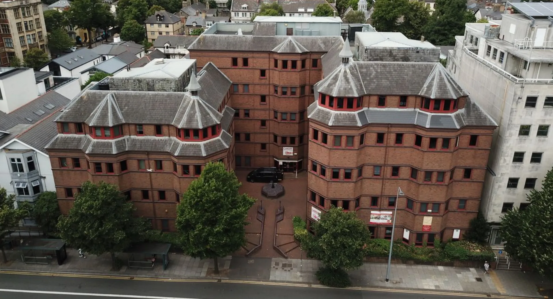 Il Cardiff Sixth Form College mostra un complesso di edifici in mattoni rossi con torri e spazi verdi circostanti.