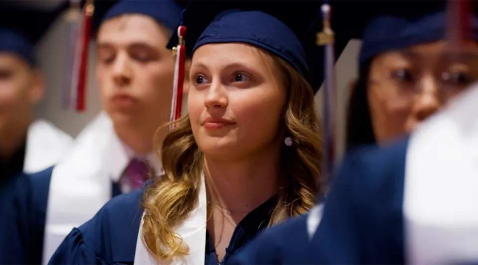 Un gruppo di diplomati in toga blu alla cerimonia di diploma della British International School Houston.
